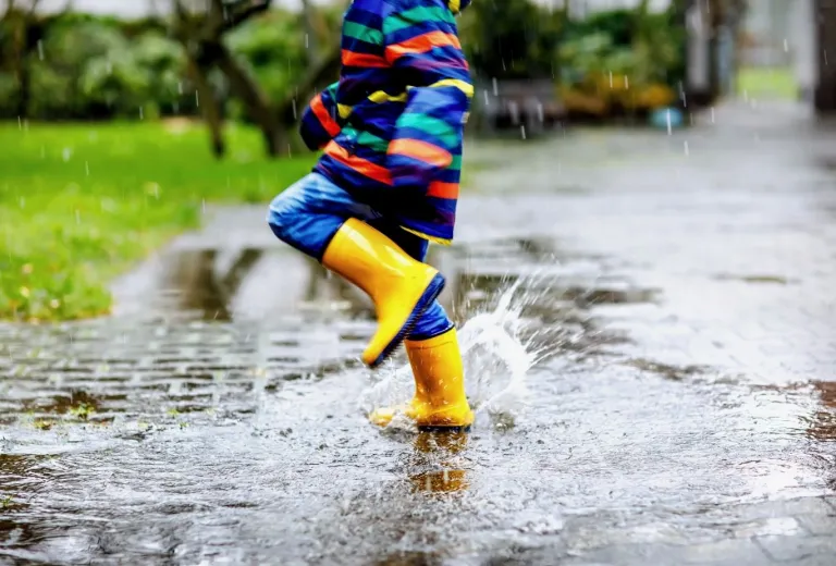 Child splashing in puddles.
