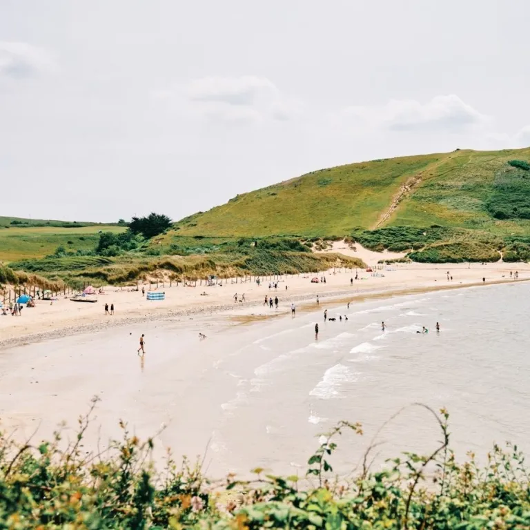 Daymer Bay with swimmers and sunbathers.