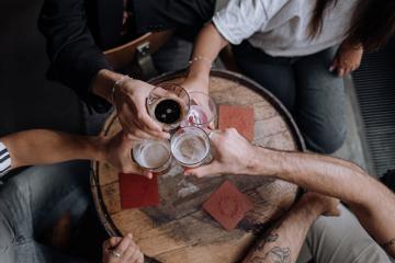 Friends clinking their glasses of ale in a pub.