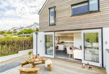 An open plan living area that opens out onto a decked terrace