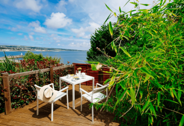 A bistro table overlooking Newlyn Harbour from a garden