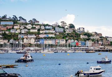 Dartmouth harbour with colourful boats in the foreground.