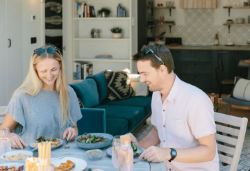 A blonde woman and a dark-haired man enjoying lunch outdoors