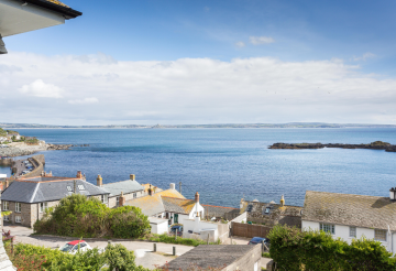 View over houses and the sea in the distance in Mousehole.
