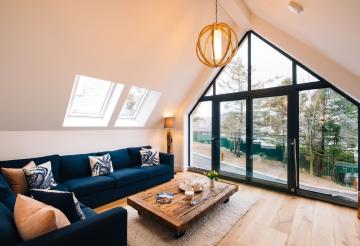 A living area with a large gable window and a wooden coffee table
