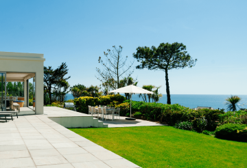 A large garden showing a dining table and sea views