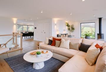 Soft pale pink sofa, round coffee table and wall mounted Smart TV.