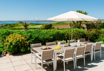 A garden and dining table overlooking St Michael's Mount in Cornwall