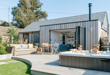 A holiday home with a young couple sitting in the hot tub