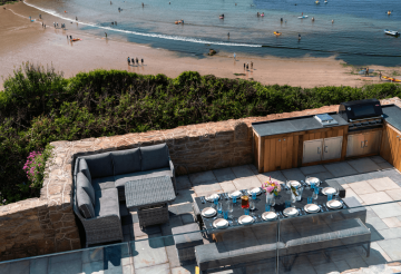 An outdoor dining table on a terrace overlooking the sea